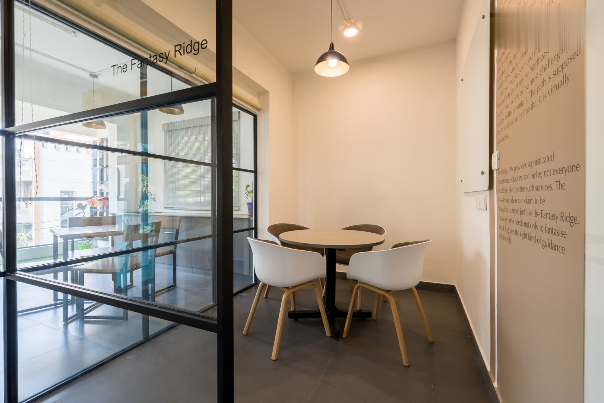 Glass-fronted meeting room beside the balcony seating with daylight through the windows
