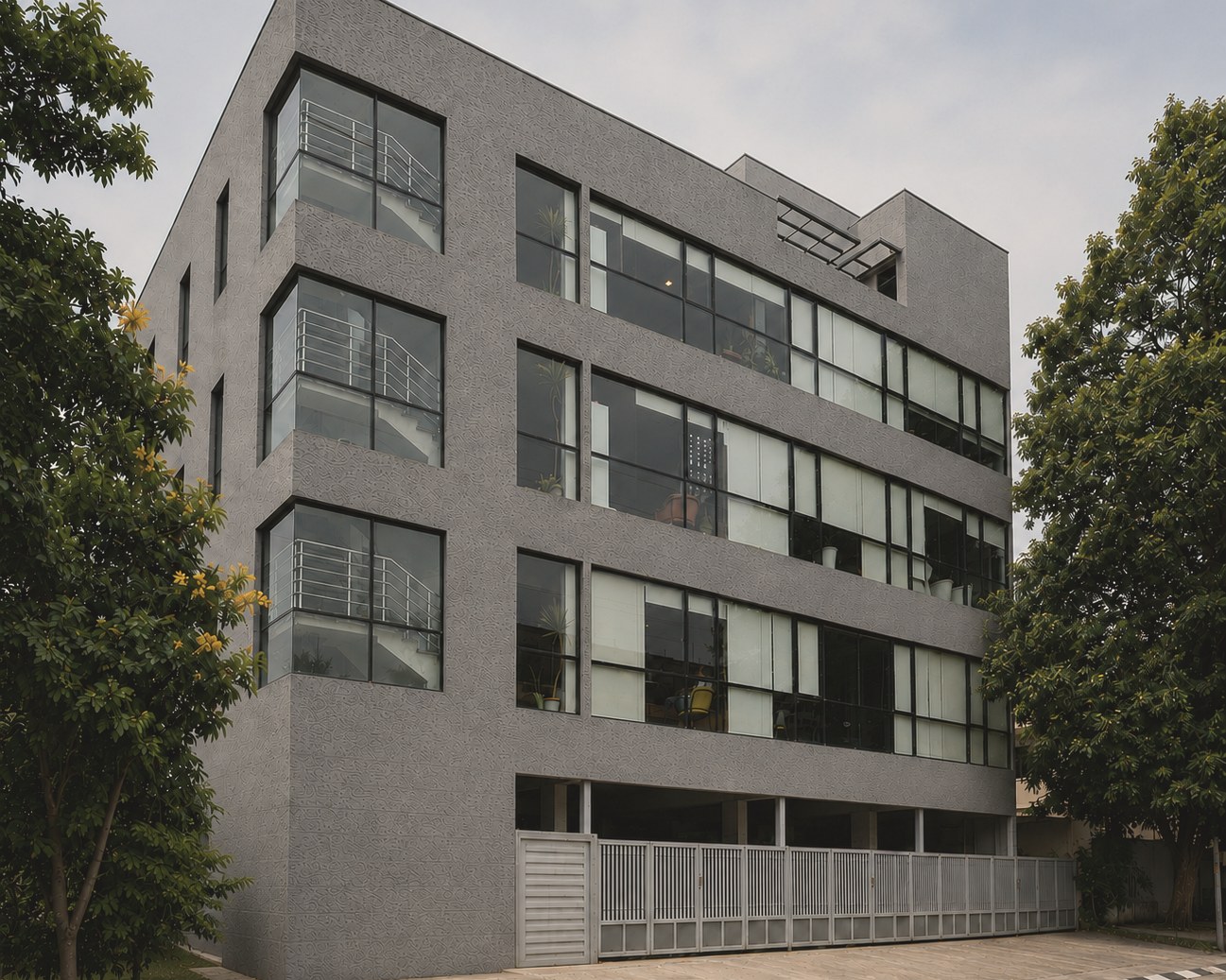 Steadwork Jayanagar building exterior, textured grey facade with planted balconies and a glazed stair core